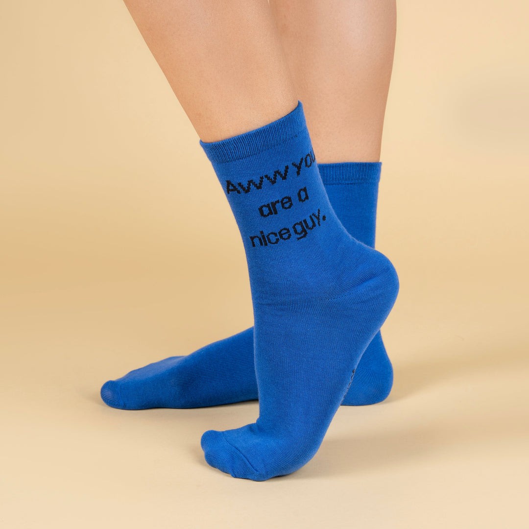 Blue socks with text worn by a person on a beige background