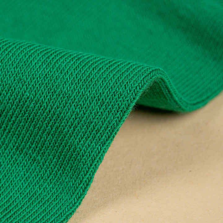 Close-up of green fabric with a beige background