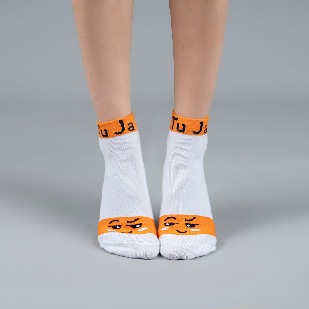 White socks with orange accents and smiley face design on a gray background