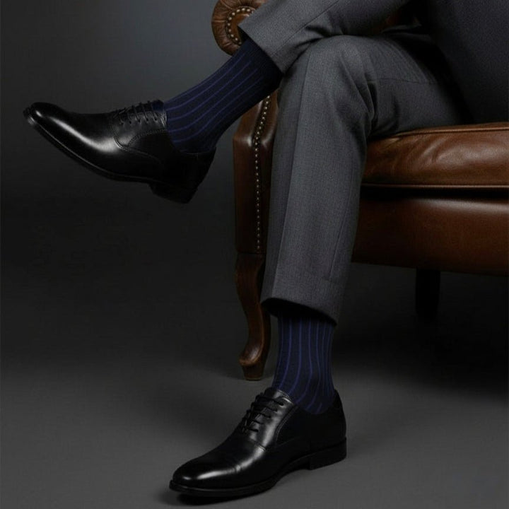 Person wearing dark gray suit and black shoes with striped socks sitting on a brown leather chair.-SOLIDCOLOR EDITION- ORGANIC COTTON-