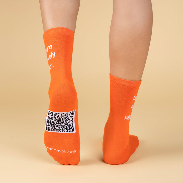 Orange socks with QR code on a beige background-Emotional Blackmail Edition- DIALOGUE SOCKS-